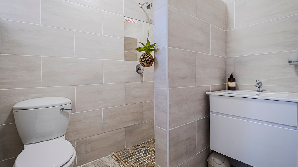 A toilet, shower and wash basin at the two bedroom apartment.