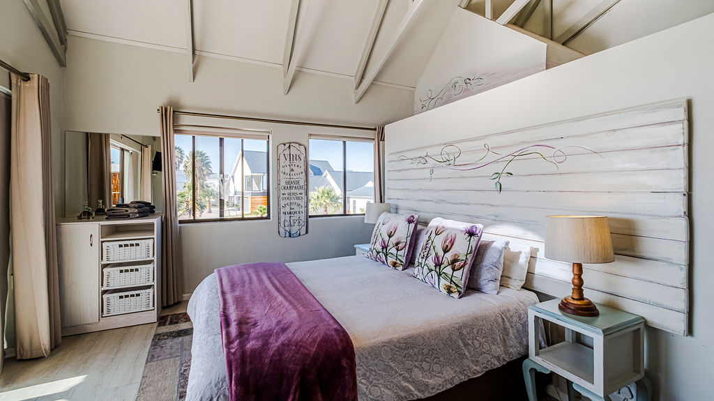 Another view of the Cabin's large bed, with a view of the marina through the window.